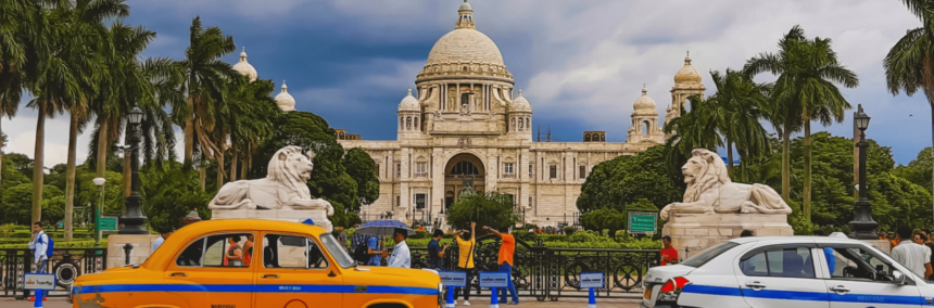 victoria memorial with yellow taxi in front