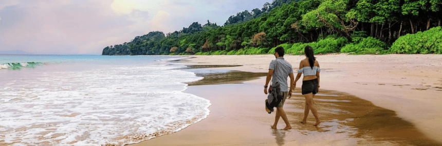 A couple walking on the beach holding hands