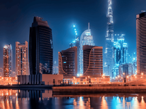 A evening photograph of Dubai skyline with reflection in water.