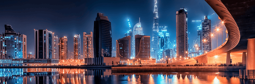 A evening photograph of Dubai skyline with reflection in water.