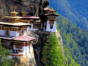 A monastery sits majestically on the edge of a cliff, overlooking a vast landscape below.