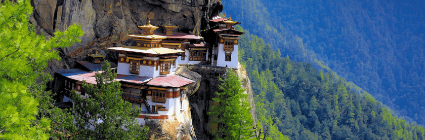A monastery sits majestically on the edge of a cliff, overlooking a vast landscape below.